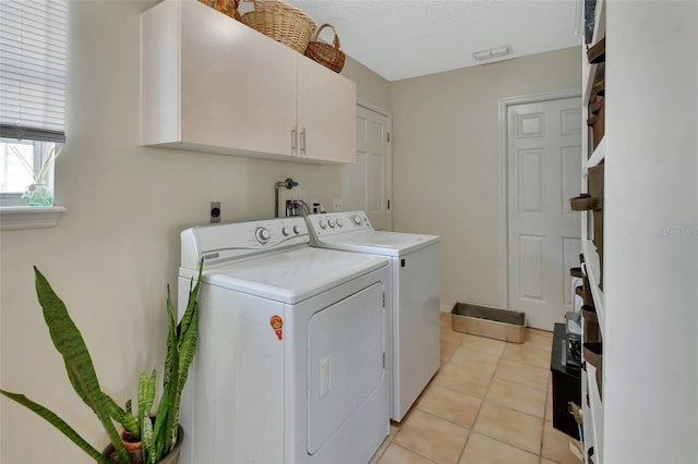 laundry area with light tile patterned floors, a textured ceiling, visible vents, independent washer and dryer, and cabinet space