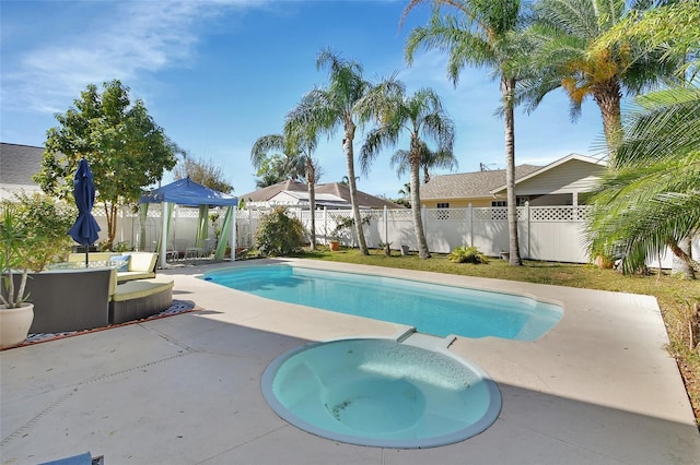 view of swimming pool with a fenced in pool, a patio area, a fenced backyard, and an in ground hot tub