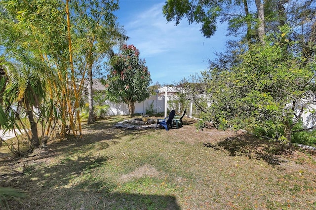 view of yard with fence and a fire pit