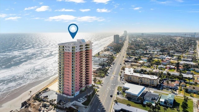 drone / aerial view featuring a water view, a beach view, and a city view