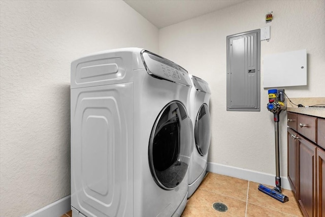 laundry area with light tile patterned floors, cabinet space, electric panel, independent washer and dryer, and baseboards