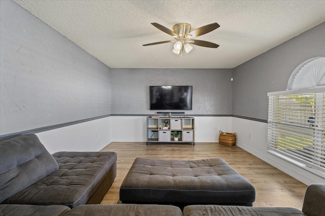 living area with a textured ceiling, wood finished floors, and a ceiling fan