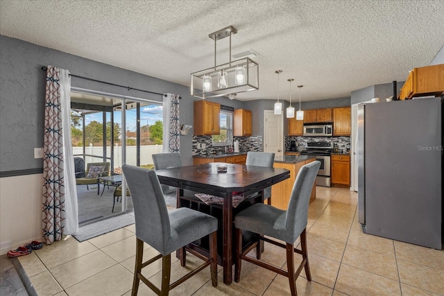 dining space with a textured ceiling and light tile patterned flooring