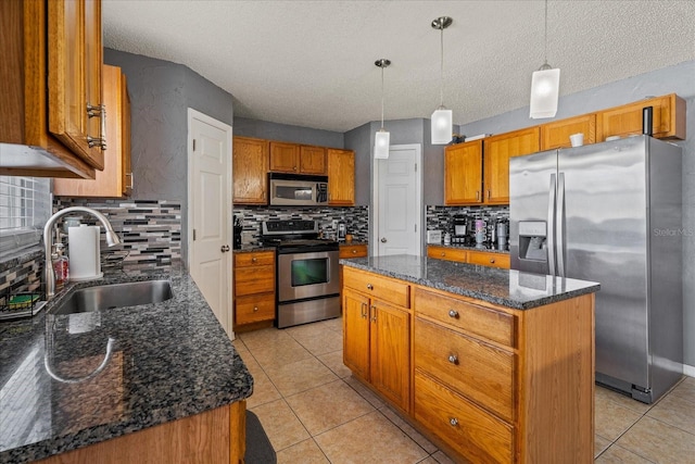 kitchen featuring brown cabinets, a sink, a center island, appliances with stainless steel finishes, and light tile patterned floors