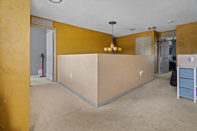 interior space featuring visible vents, carpet flooring, and a textured wall