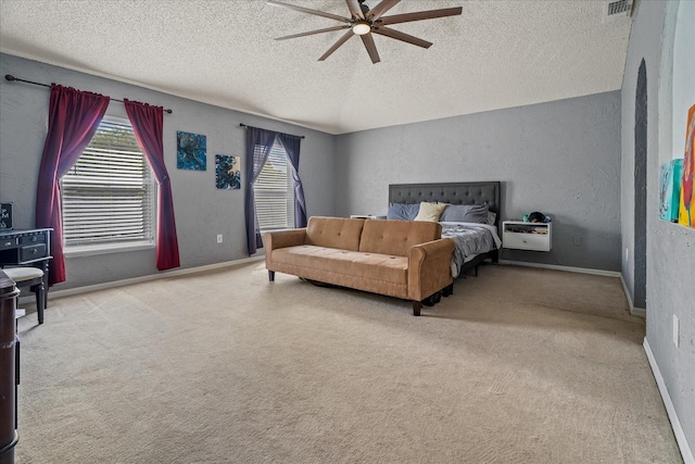 bedroom featuring carpet, a ceiling fan, a textured wall, and a textured ceiling