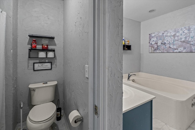 bathroom with a garden tub, toilet, and vanity