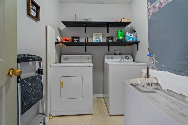 washroom featuring washing machine and clothes dryer, laundry area, and light tile patterned flooring