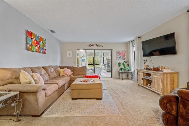 carpeted living room with visible vents and a textured ceiling