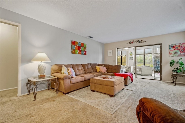 living room featuring visible vents, carpet flooring, a textured ceiling, and baseboards