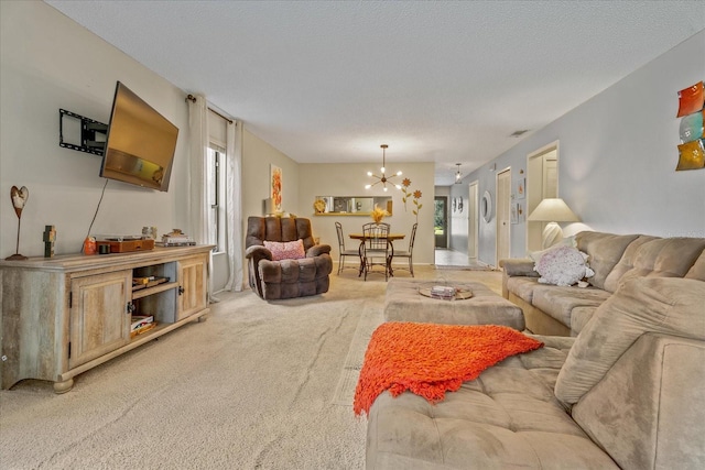 living room featuring light carpet, plenty of natural light, a textured ceiling, and a notable chandelier