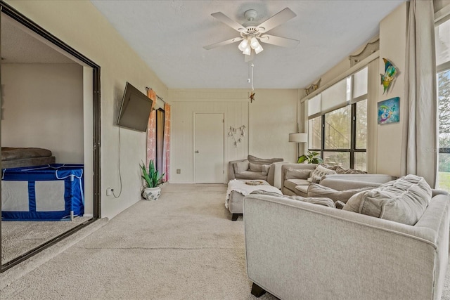 carpeted living area with ceiling fan