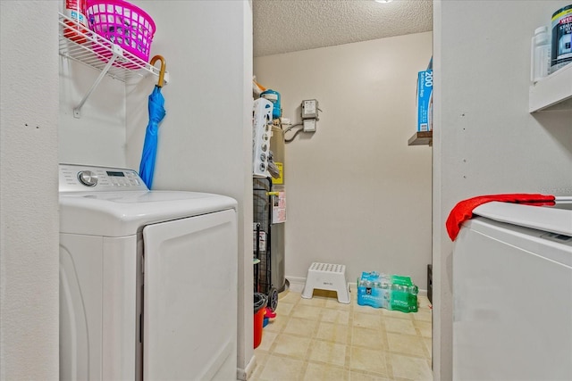 laundry room featuring washing machine and clothes dryer, laundry area, tile patterned floors, and a textured ceiling