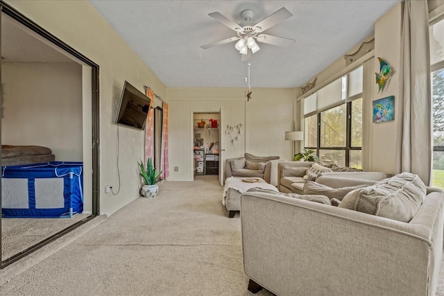 carpeted living area featuring a ceiling fan