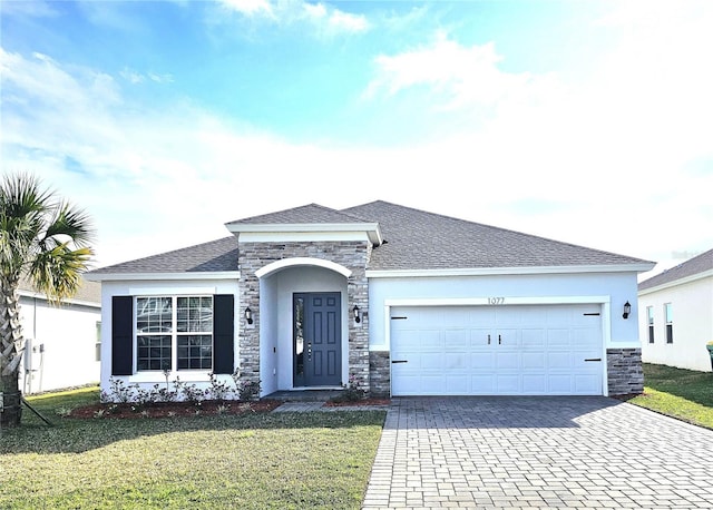 ranch-style home with a garage, stone siding, decorative driveway, stucco siding, and a front lawn