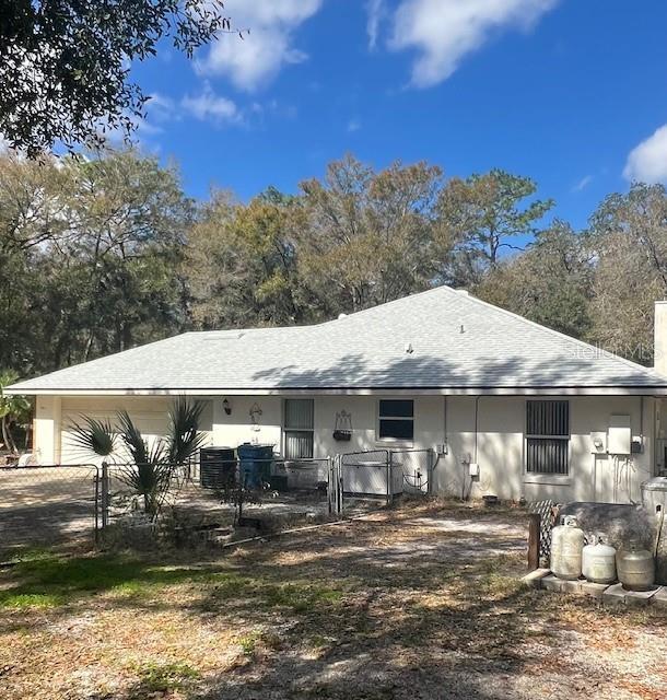 back of property featuring a garage and fence