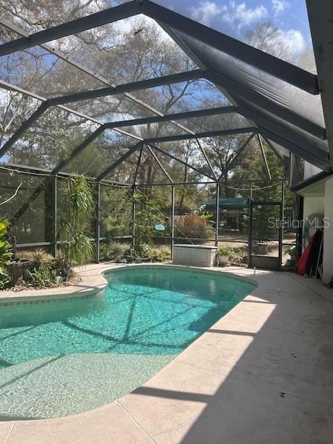 outdoor pool featuring a lanai and a patio