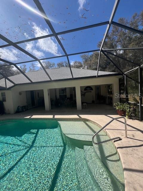 pool with a lanai and a patio area