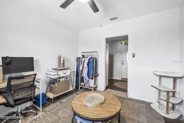 interior space with a ceiling fan, baseboards, visible vents, and a textured ceiling