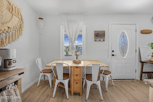 dining room featuring baseboards and light wood-style floors