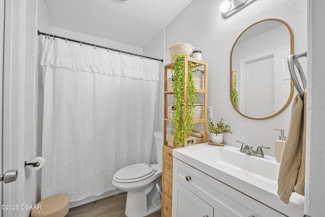 bathroom featuring toilet, a shower with curtain, wood finished floors, and vanity