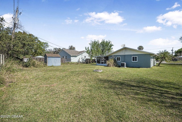 view of yard with central air condition unit, a storage shed, a sunroom, and an outdoor structure