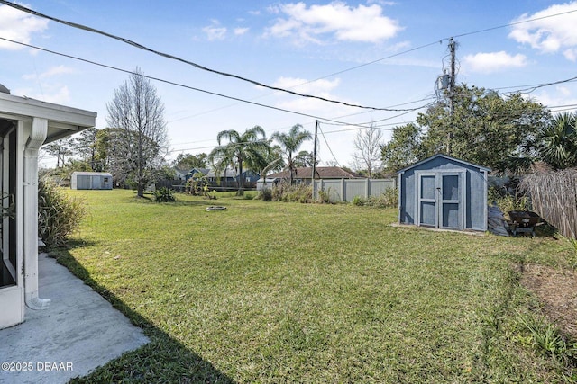 view of yard with a fenced backyard, an outdoor structure, and a shed