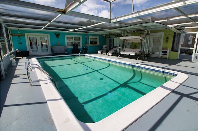 pool with french doors, a patio, and glass enclosure