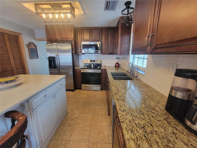 kitchen with visible vents, backsplash, appliances with stainless steel finishes, a sink, and a textured ceiling