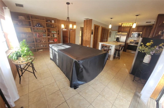 kitchen featuring visible vents, a center island, appliances with stainless steel finishes, and light tile patterned flooring