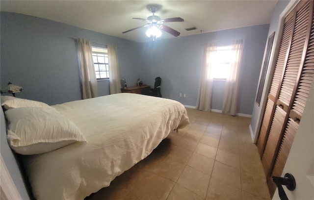 bedroom with baseboards, visible vents, a ceiling fan, and tile patterned floors