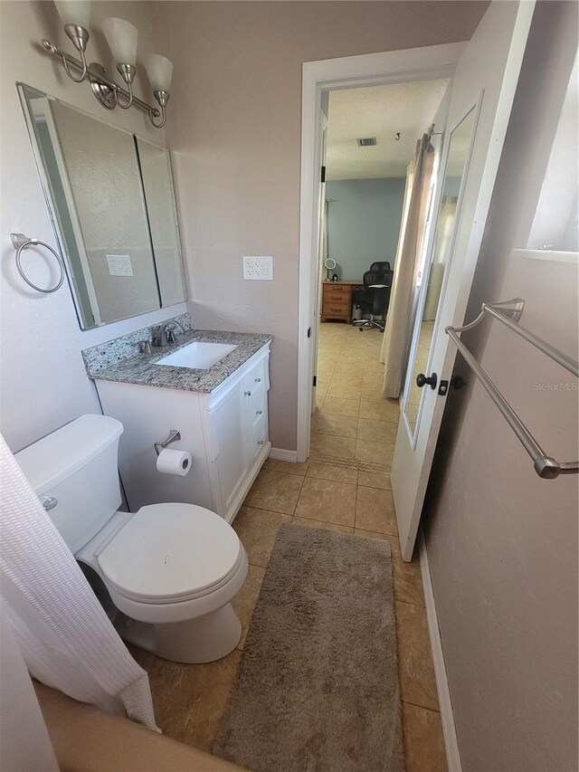 bathroom with toilet, tile patterned flooring, and vanity