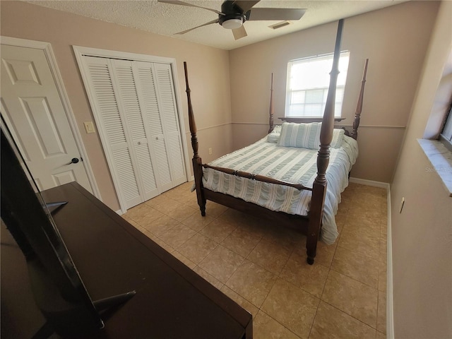 bedroom with a closet, light tile patterned flooring, ceiling fan, and visible vents