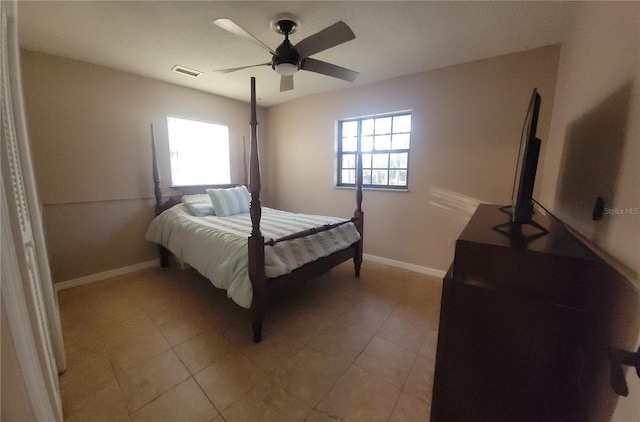 bedroom with a ceiling fan, visible vents, baseboards, and multiple windows