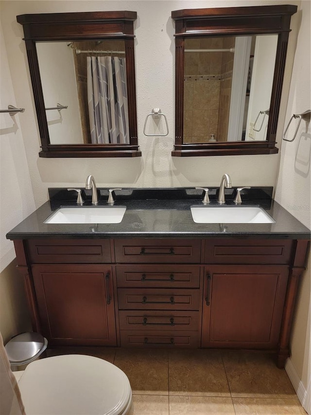 bathroom with double vanity, a sink, toilet, and a shower with curtain