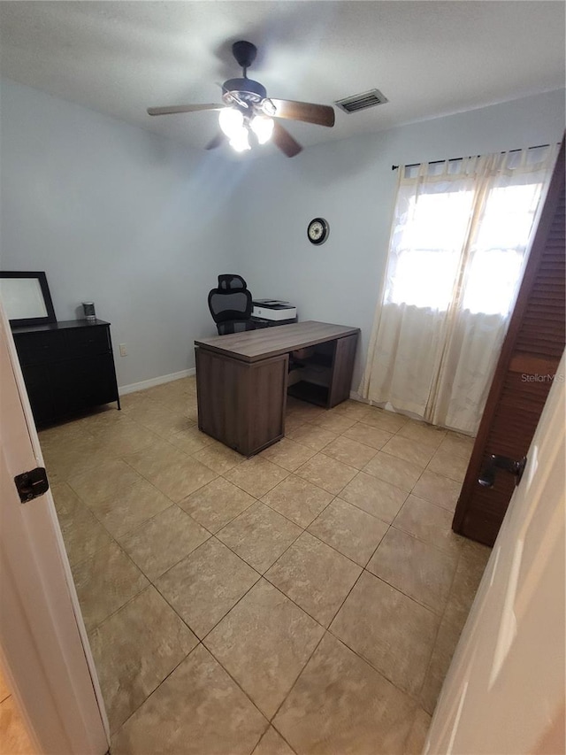 home office featuring visible vents, ceiling fan, baseboards, and light tile patterned floors