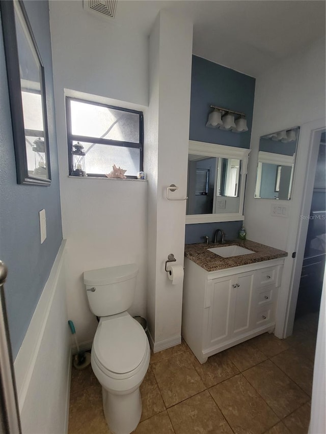 bathroom with toilet, visible vents, vanity, and tile patterned floors