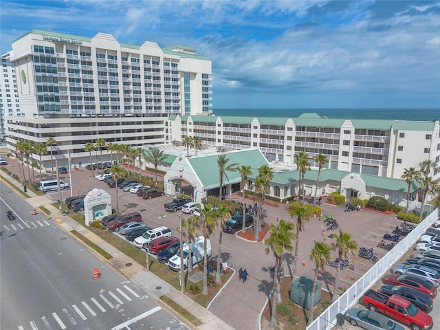 view of building exterior featuring uncovered parking and a water view