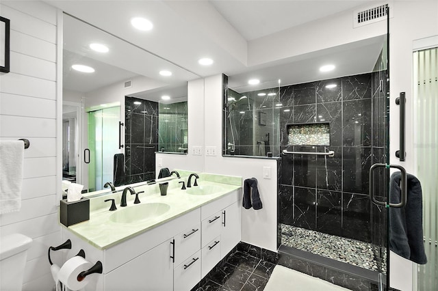 full bathroom with visible vents, a sink, toilet, and a shower stall