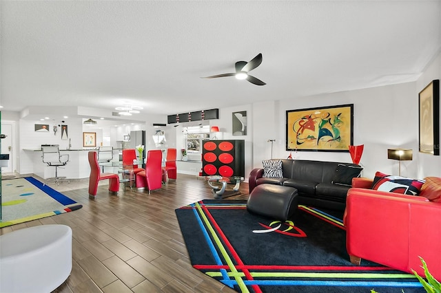 living room featuring a textured ceiling, wood finish floors, and a ceiling fan