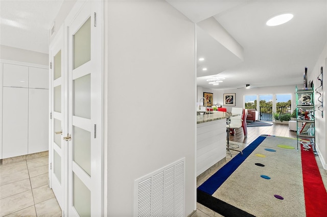 hallway featuring recessed lighting, visible vents, a sink, and light tile patterned flooring