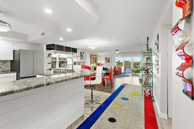 kitchen with recessed lighting, a ceiling fan, white cabinetry, freestanding refrigerator, and decorative backsplash