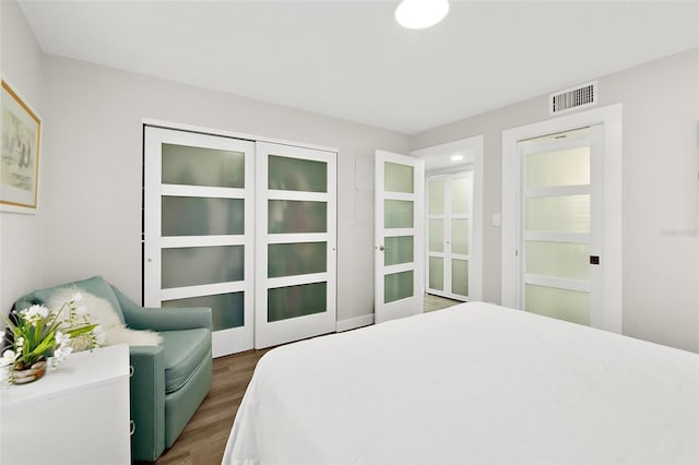 bedroom featuring visible vents and wood finished floors