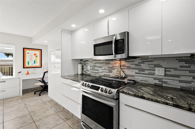 kitchen featuring white cabinetry, modern cabinets, appliances with stainless steel finishes, and built in study area