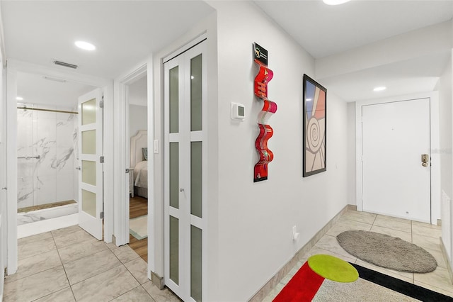 corridor featuring light tile patterned floors, visible vents, and recessed lighting