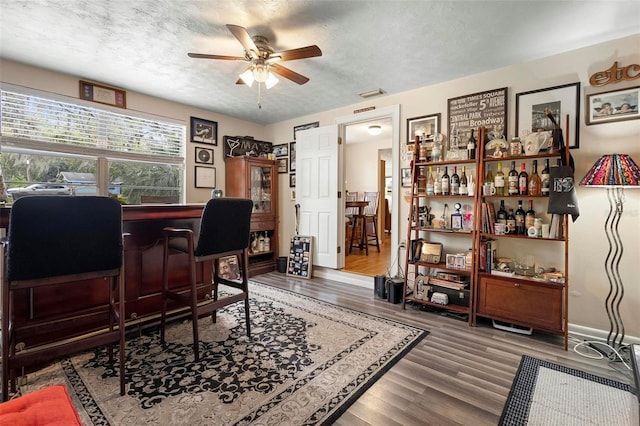 office featuring a textured ceiling, wood finished floors, and a ceiling fan