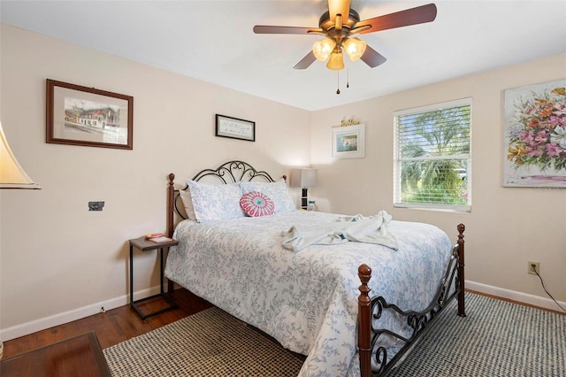 bedroom featuring a ceiling fan, baseboards, and wood finished floors