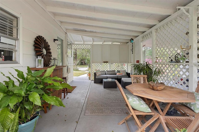 unfurnished sunroom with a wealth of natural light and vaulted ceiling with beams