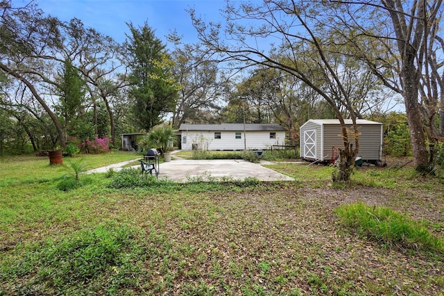 view of yard with an outbuilding, a storage shed, and a patio area