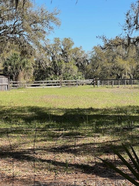 view of yard with a rural view and fence